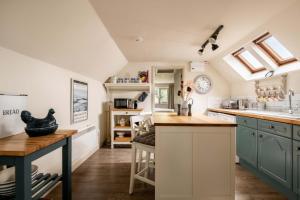 a kitchen with blue cabinets and a counter top at The Barn in South Cerney +11 photos
