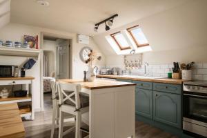 a kitchen with blue cabinets and a counter top at The Barn in South Cerney