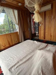 a bedroom with a white bed with a window at Peaceful Waterfall Homestay - Nhà Bên Thác in Hoat