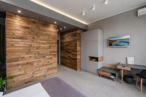 a bedroom with a wooden accent wall and a desk at Poet Art Hotel in Odesa