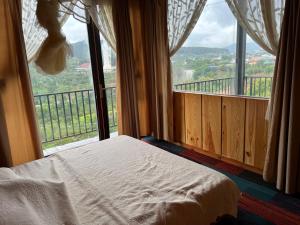 a bed in a room with a large window at Peaceful Waterfall Homestay - Nhà Bên Thác in Hoat
