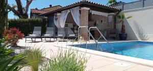 a swimming pool with chairs next to a house at Casa Providenca in Kaštelir