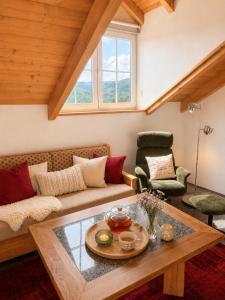 a living room with a couch and a table at Helle Ferienwohnung im Bayerischen Wald mit Balkon, Garten & viel Platz für 4 in Mauth