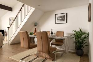 a dining room with a table and chairs at Aintree Cottage in Cirencester