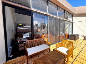 a balcony with two benches and a large window at Duplex Close to HPU Waikiki Pool Terrace Laundry One and Half Bath for 15person in Honolulu