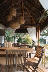 a dining room with a table and chairs and nets at Mareias Villas in São Miguel do Gostoso
