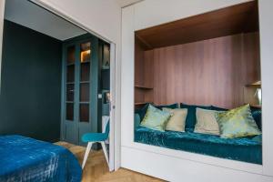 1 dormitorio con 1 cama y 1 sofá azul en Studio Royan en Royan