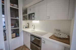 eine weiße Küche mit einer Spüle und einem Herd in der Unterkunft Studio Royan in Royan