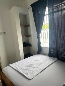 a bed in a room with a window at Amour Coco Stay in Chaki Chaki