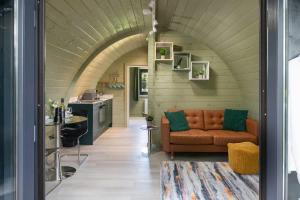 a living room with a couch and a kitchen at Squirrels Drey in Hankerton