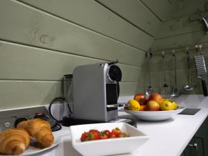 a kitchen counter with a plate of fruit and a bowl of bread at Squirrels Drey in Hankerton