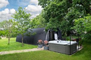 a hot tub in a backyard with a yard at Squirrels Drey in Hankerton +8 photos