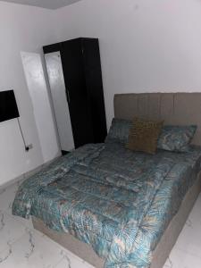 a bedroom with a bed and a lamp at Urban Nest Lodge in Ikeja
