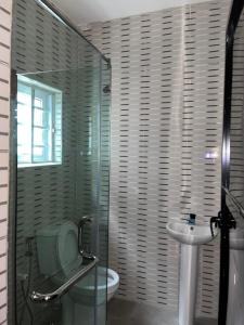 a bathroom with a shower and a toilet and a sink at Urban Nest Lodge in Ikeja
