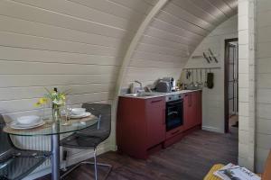 a kitchen with red cabinets and a table in a room at Foxes Den in Hankerton +10 photos