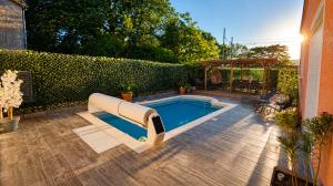 a swimming pool with a slide in a backyard at Loge au ptitbonheur in Savasse