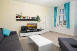 a living room with a couch and a tv at Ferienwohnung 10 Haus Metropol in Binz