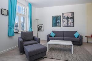 a living room with a couch and a chair at Ferienwohnung 10 Haus Metropol in Binz +10 photos