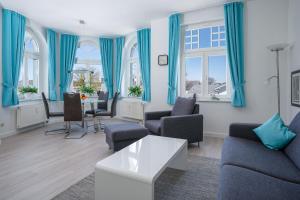 a living room with blue curtains and a table at Ferienwohnung 10 Haus Metropol in Binz