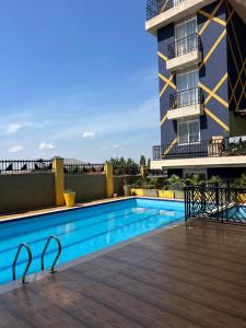 a swimming pool in front of a building at Plush stays UG in Buwate