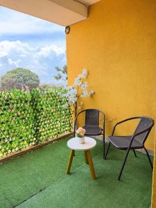 a patio with two chairs and a table and a fence at Plush stays UG in Buwate