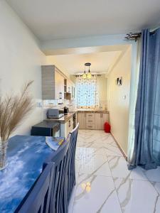 a kitchen and a dining room with a table at Plush stays UG in Buwate