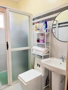 a bathroom with a sink and a toilet and a mirror at Plush stays UG in Buwate +8 photos
