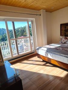 a bedroom with a bed and a large window at Saadhan Homestay in Mussoorie +22 photos