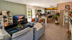 a living room with two couches and a kitchen at Loge au ptitbonheur in Savasse