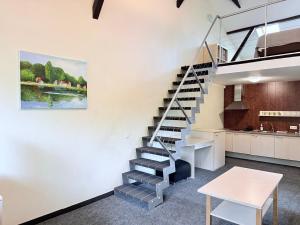 a staircase in a room with a kitchen and a table at Nidos kempingas in Nida