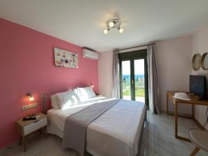 a bedroom with a large bed with a pink wall at Freesia Grand Sea View Residence in Sarláta