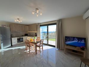 a kitchen with a table with chairs and a television at Freesia Grand Sea View Residence in Sarláta
