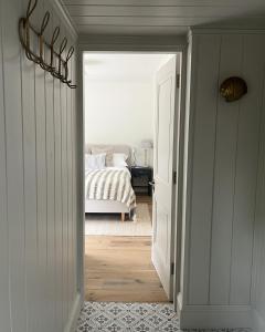 a hallway leading to a bedroom with a bed at Stamping Cottage Studio Between St Ives & Penzance in Penzance +12 photos