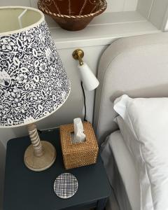 a lamp on a night stand next to a bed at Stamping Cottage Studio Between St Ives & Penzance in Penzance