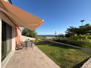a patio with a table and chairs and an umbrella at Freesia Grand Sea View Residence in Sarláta
