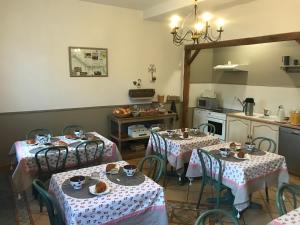 a kitchen with two tables and a kitchenasteryasteryasteryasteryasteryasteryasteryastery at "Les Charmilles" - Maison de charme dans un ancien cloître in Sailly-Flibeaucourt