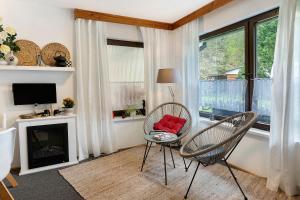 a living room with two chairs and a table and a fireplace at Rosenberg in Katzhütte