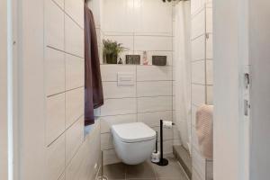 a white toilet in a bathroom with white tiles at Rosenberg in Katzhütte +12 photos