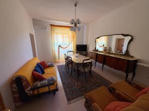 a living room with a couch and a table and a mirror at La casa di nonna Gianna in Gonnesa