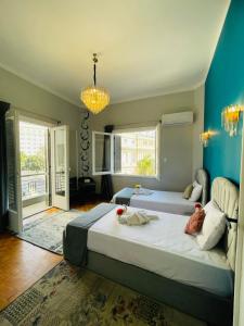 a bedroom with two beds and a blue wall at Le caire Hotel & suits in Cairo