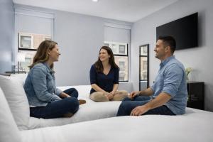 a group of three people sitting on a bed at OYO Times Square in New York