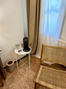 a coffee maker sitting on a table next to a chair at VTZ The Orus Factory Hotel - Parking Muy Económico in Zaragoza