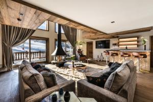 a living room with two couches and a piano at Manali Lodge by Alpine Resorts in Courchevel