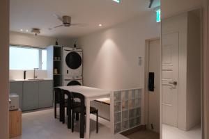 a kitchen with a table and chairs and a microwave at Covon Stay in Busan
