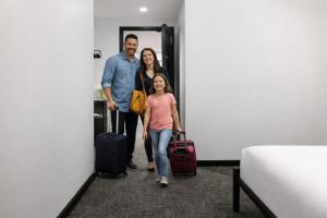 a family walking through a hallway with their luggage at OYO Times Square in New York