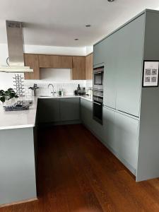 a large kitchen with white appliances and wood floors at Malachite in South Cerney +61 photos