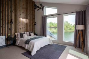 ein Schlafzimmer mit einem Bett und einem großen Fenster in der Unterkunft Maricor in South Cerney