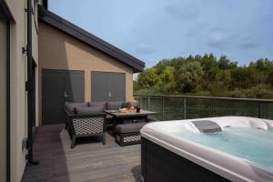 eine Terrasse mit Whirlpool und einem Tisch in der Unterkunft Maricor in South Cerney + 39 Fotos