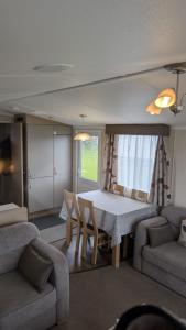 a living room with a table and a couch at The Speculation Inn - 3 Bedroom Static Caravan in Pembroke
