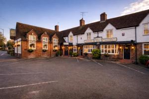 a building with a parking lot in front of it at The Tower Arms Hotel in Iver